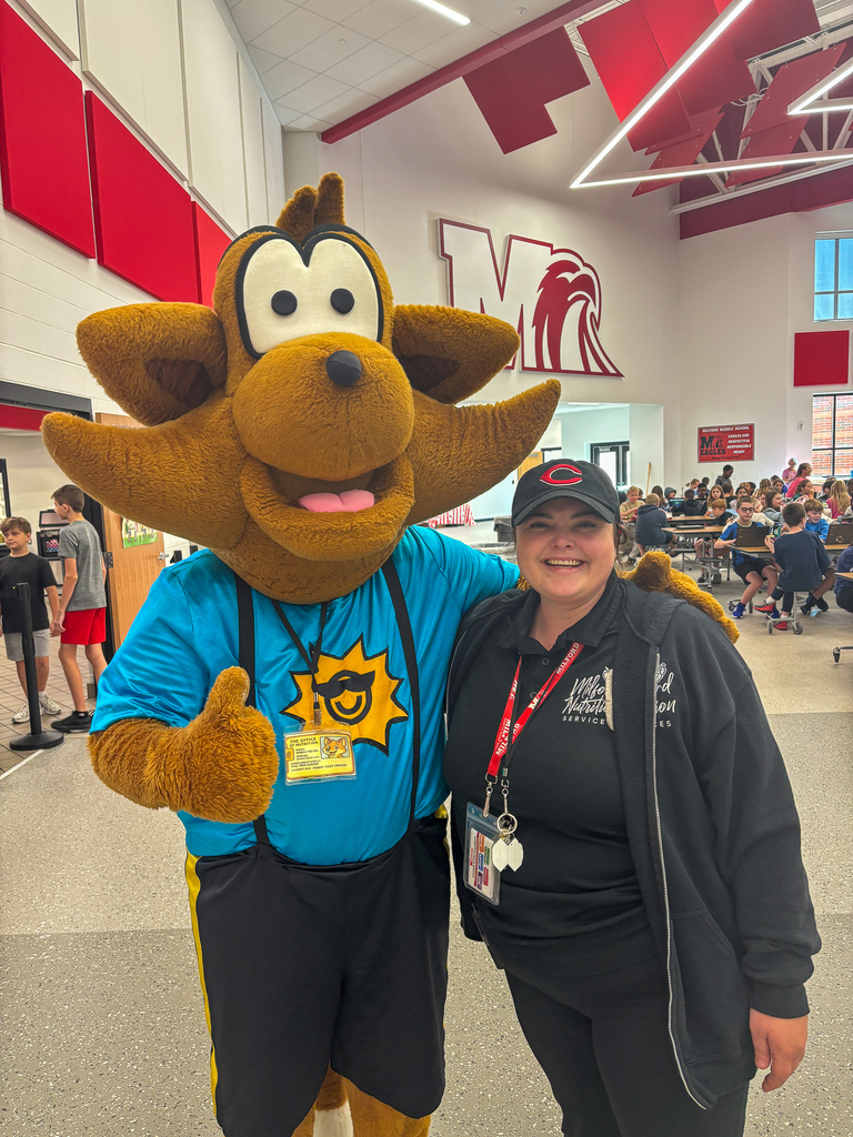 Munch the Fox gives a thumbs up while posing with a Milford School Nutrition staff member in the Milford Middle School cafeteria.