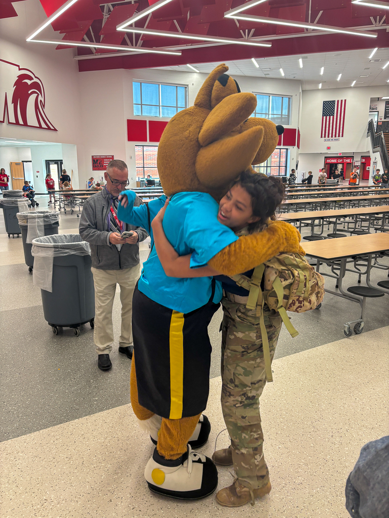 A Milford Middle School student gives Munch the Fox a hug during the mascot’s lunchtime visit.