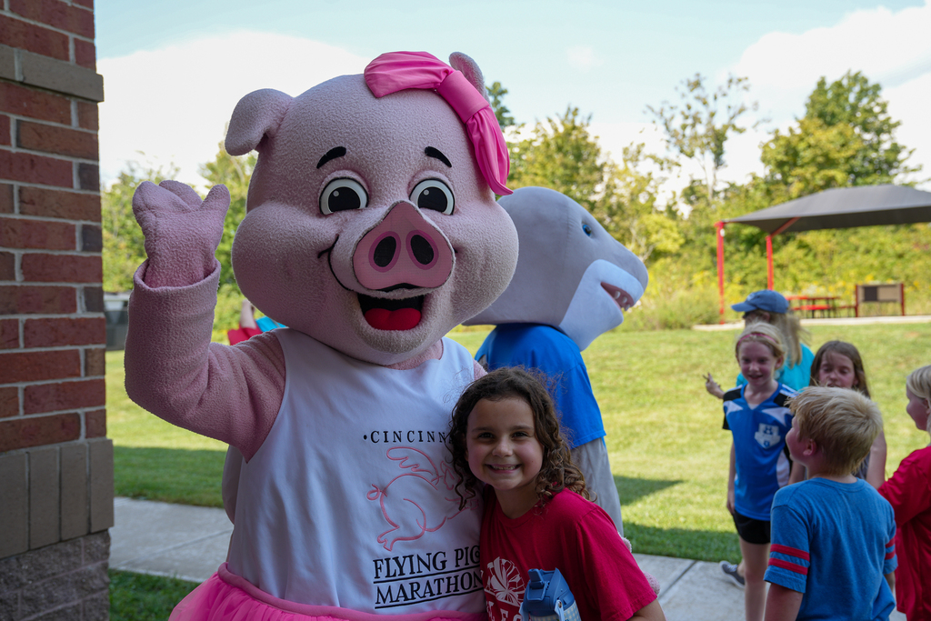 A Seipelt student smiles beside costumed pig and shark characters during the school’s walk-a-thon celebration.