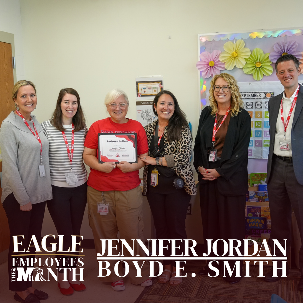 Eagle Employee of the Month Jennifer Jordan of Boyd E. Smith Elementary holds her award while posing with five colleagues in a classroom.