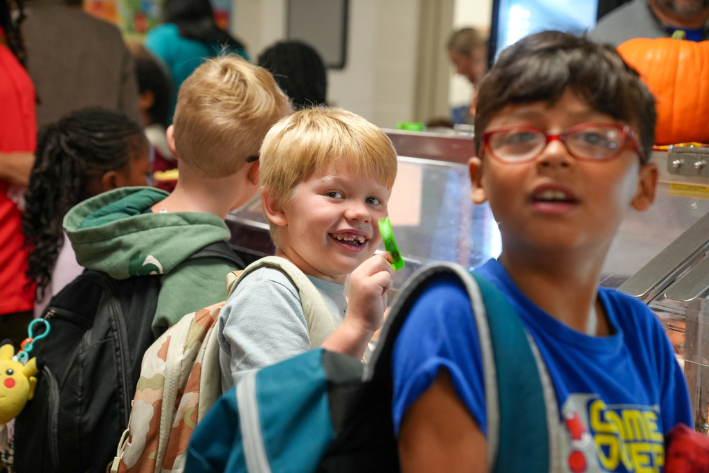 A student carries a breakfast tray through the cafeteria serving lin