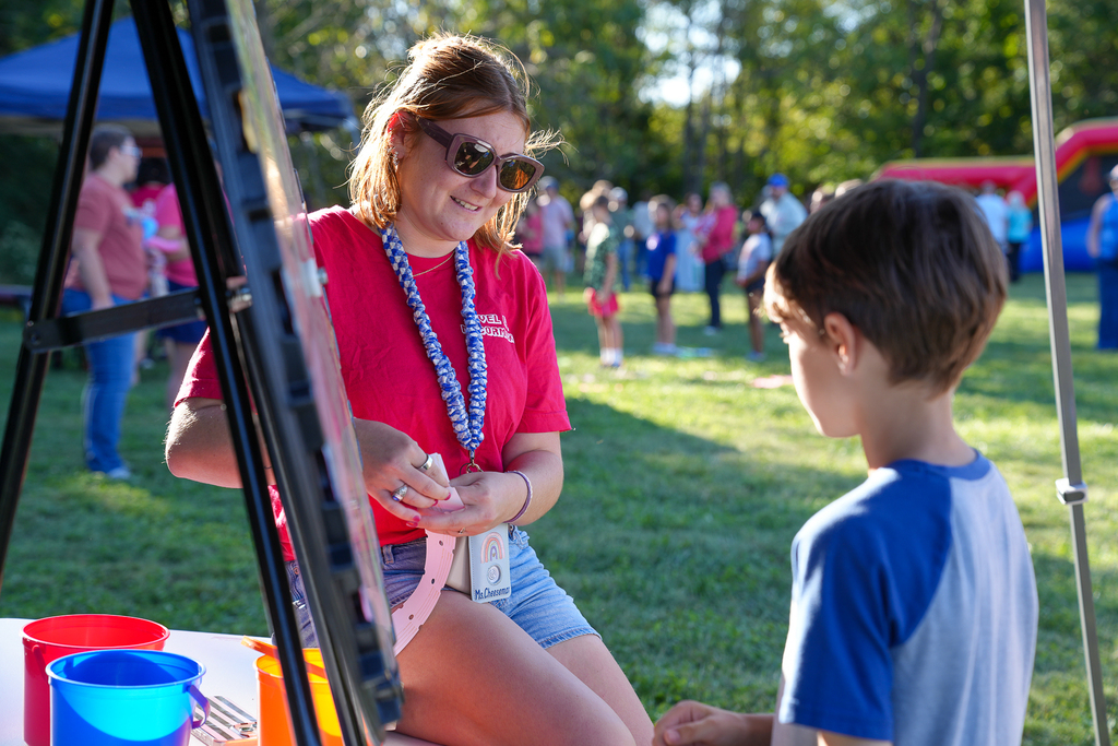 A McCormick staff member helps a student at a game station during McCormick Fest.