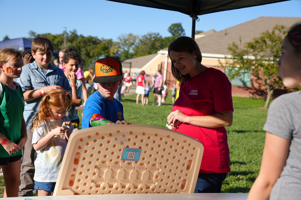 Students gather around a game station at McCormick Fest as a staff member helps lead the activity.