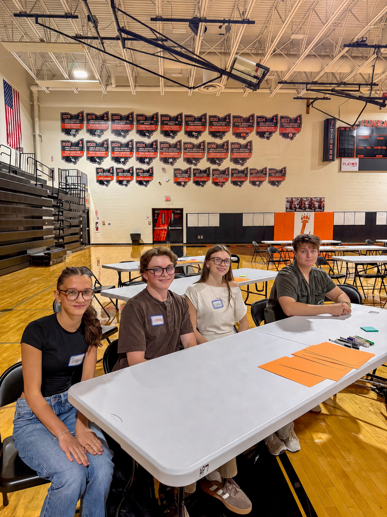 Four Milford students sit together at a table in Loveland High School’s gym during the High Aims Student Leadership Symposium.