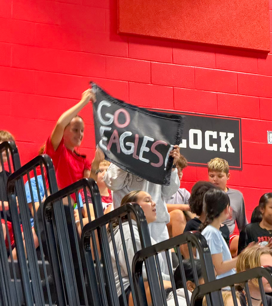 Middle School students holding up a sign saying "GO EAGLES!" 