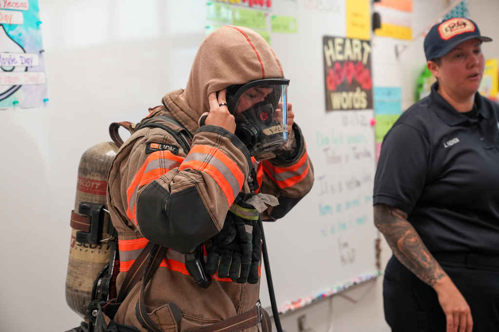 A fully suited firefighter in a classroom