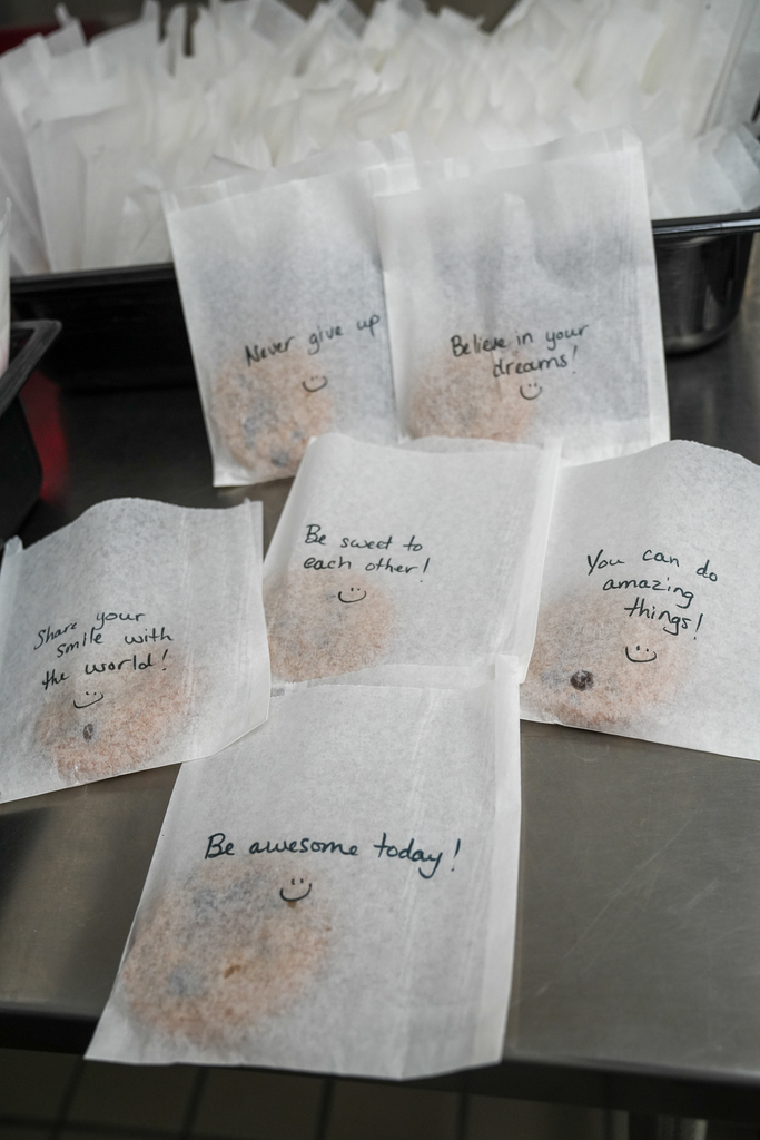 Individually bagged cookies display handwritten encouragement, including “Never give up,” “Believe in your dreams,” “Be sweet to each other,” “Share your smile with the world,” “You can do amazing things” and “Be awesome today.”