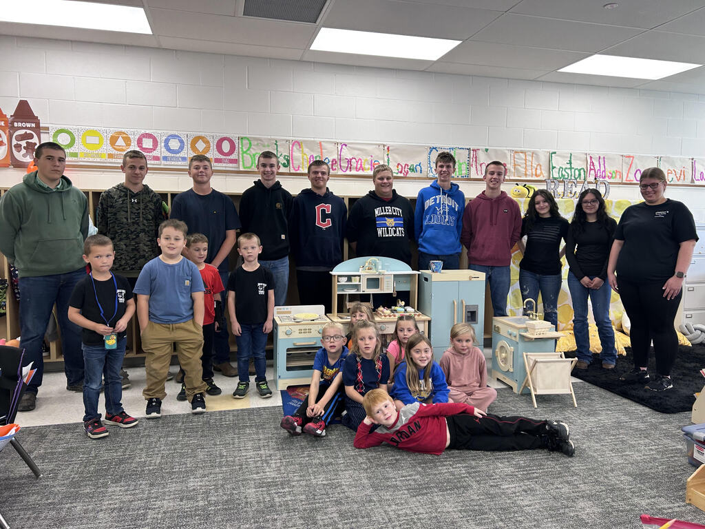Ag Ed students posing with kindergarteners and their new playset