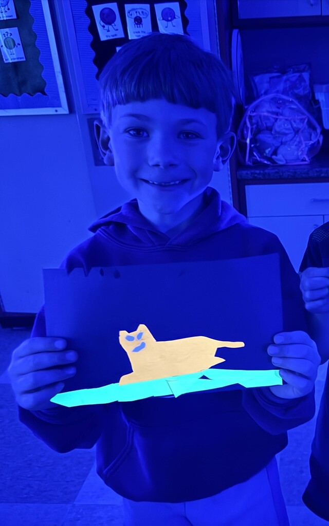 Student showing glowing artwork