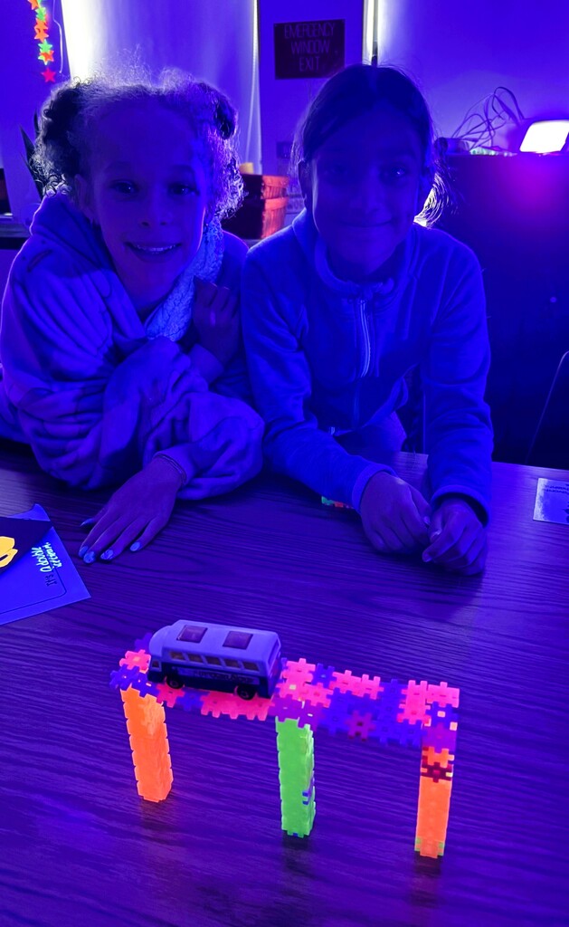 Students showing a glow in the dark bridge.