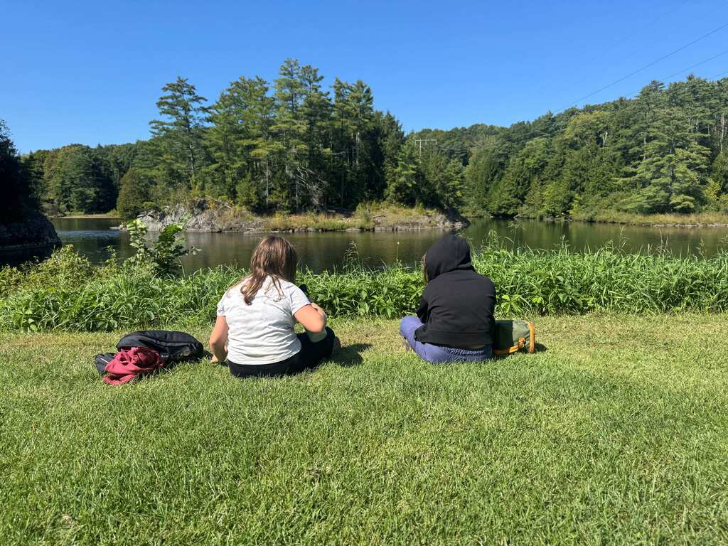 Students sitting by the river.