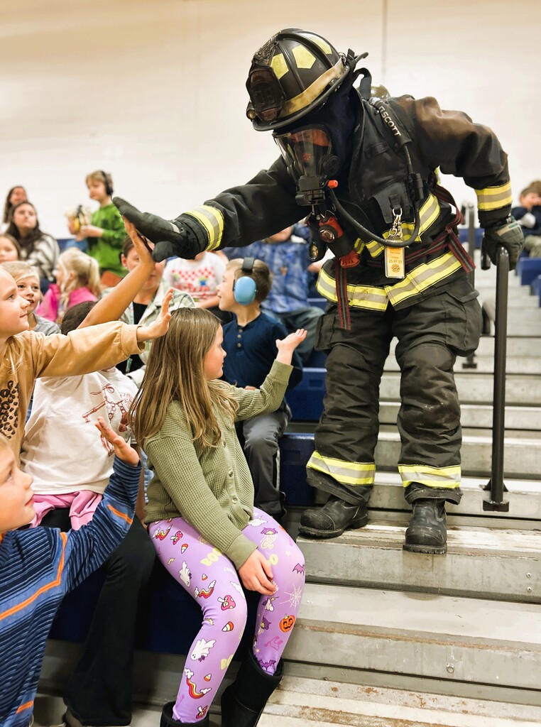firefighter high-fiving students
