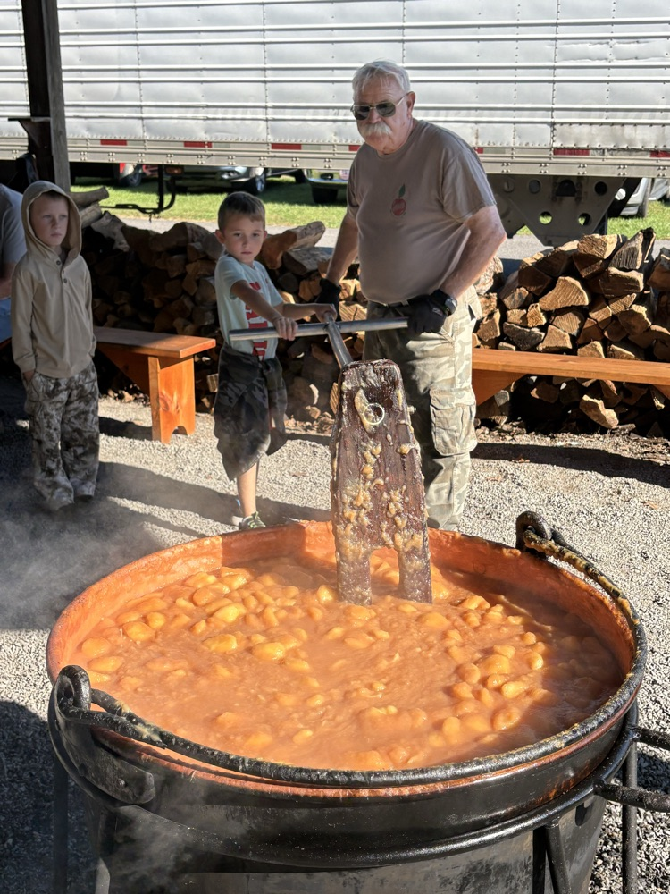 A photo of a student stirring apples at the Apple Harvest.
