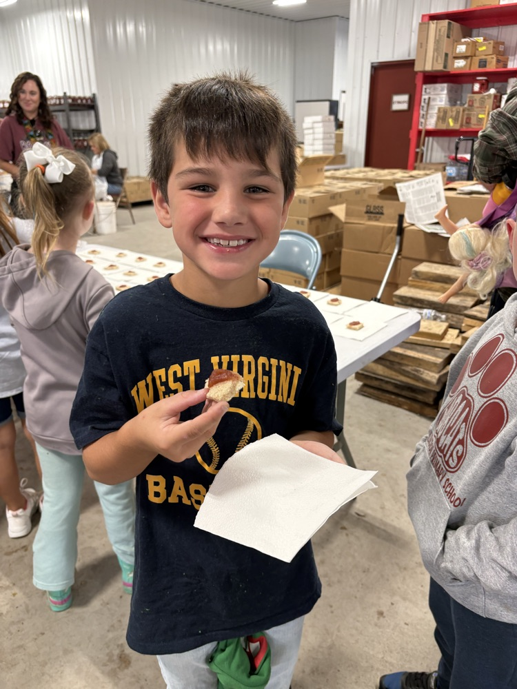 A photo of a student taste testing apple butter.