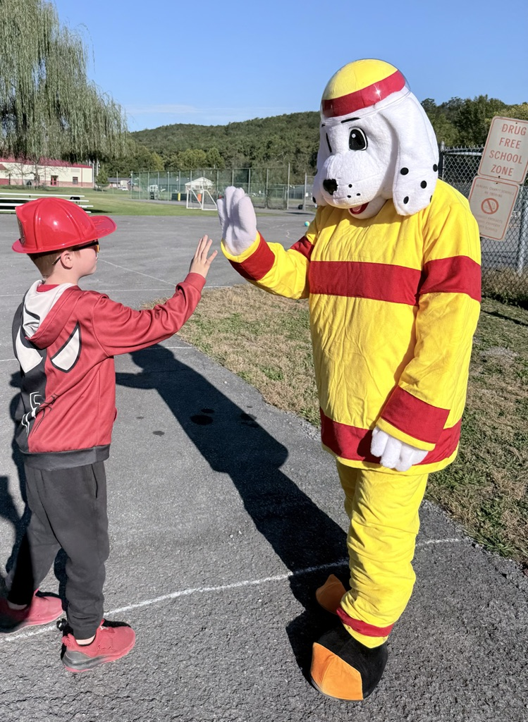 A photo of a student with Sparky the mascot at the Fire Safety presentation by the BVFD. 