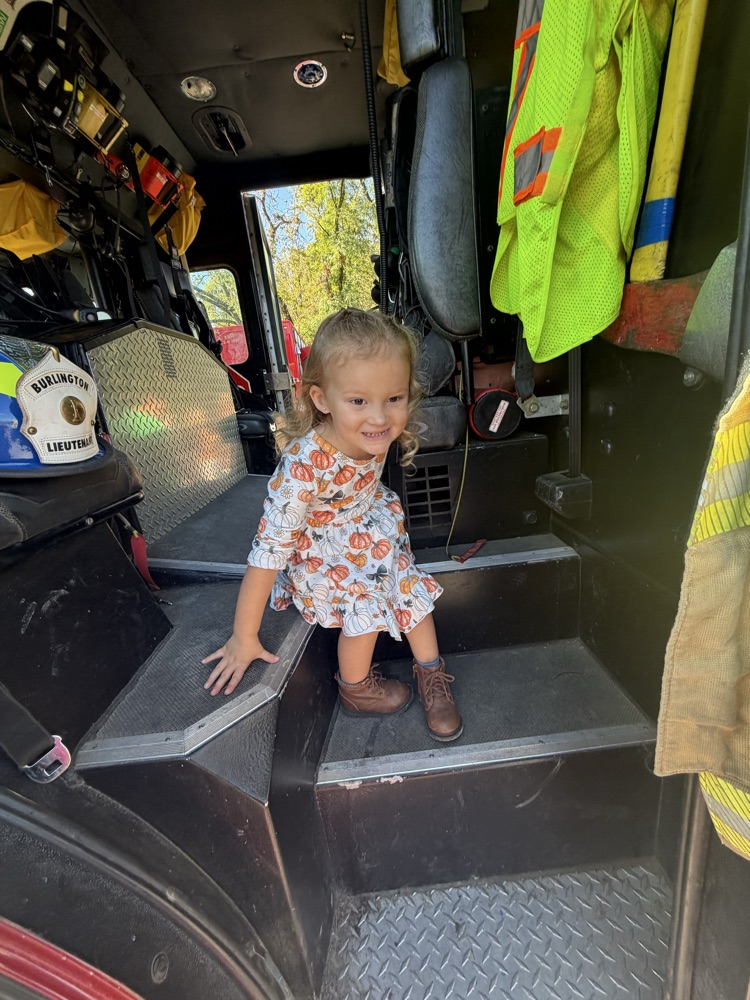 A photo of a student climbing out of a fire truck.