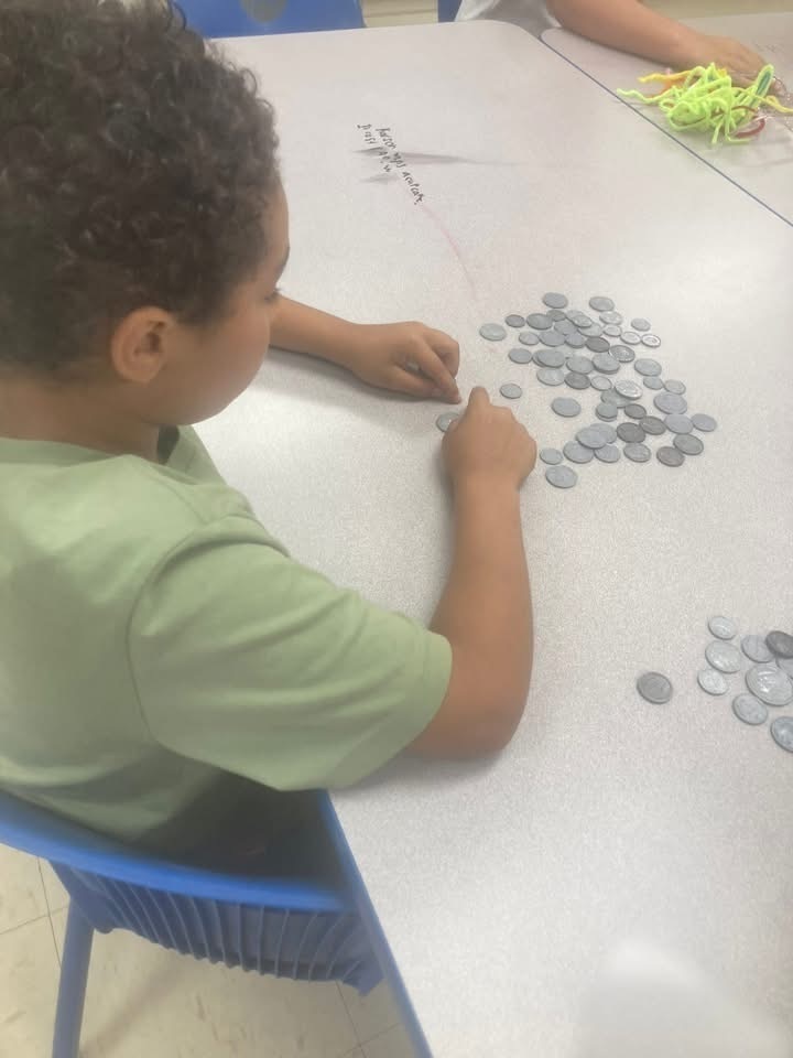 Boy in green shirt counting money on a table