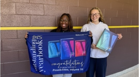 Yearbook students with banner