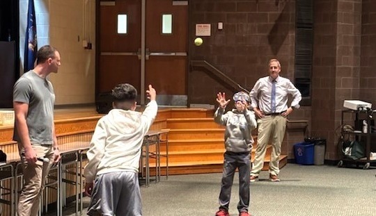 speak with students throwing a ball