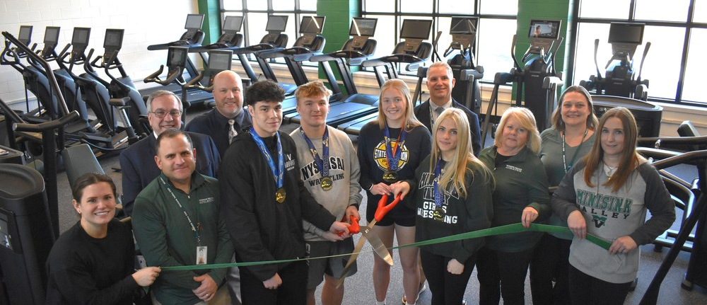 people in cardio room cutting ribbont