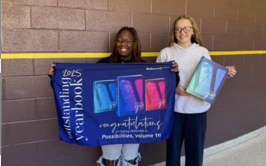 Yearbook students with banner