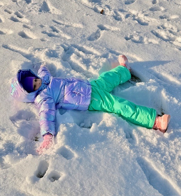 student making snow angel
