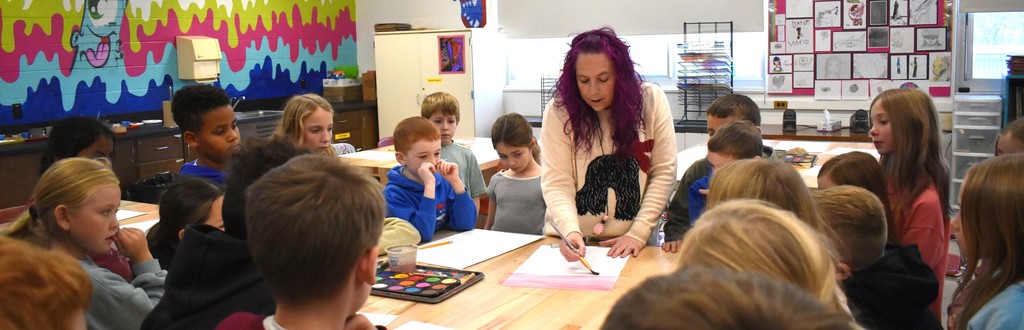 student with teacher in art class