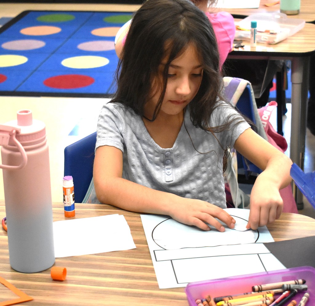 student making paper snowman