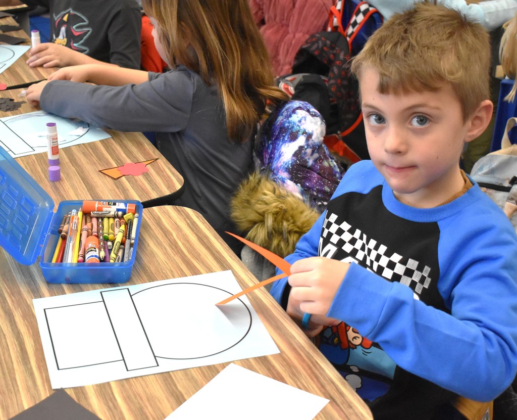 student making paper snowman