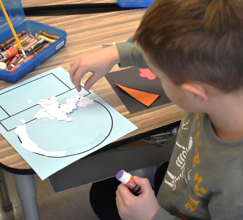 student making paper snowman