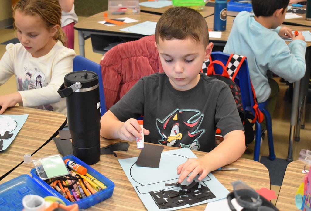 student making paper snowman