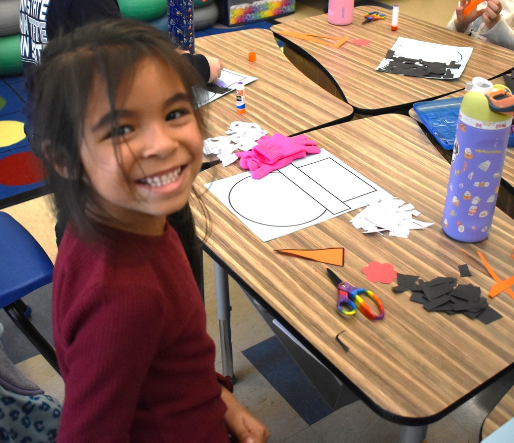 student making paper snowman