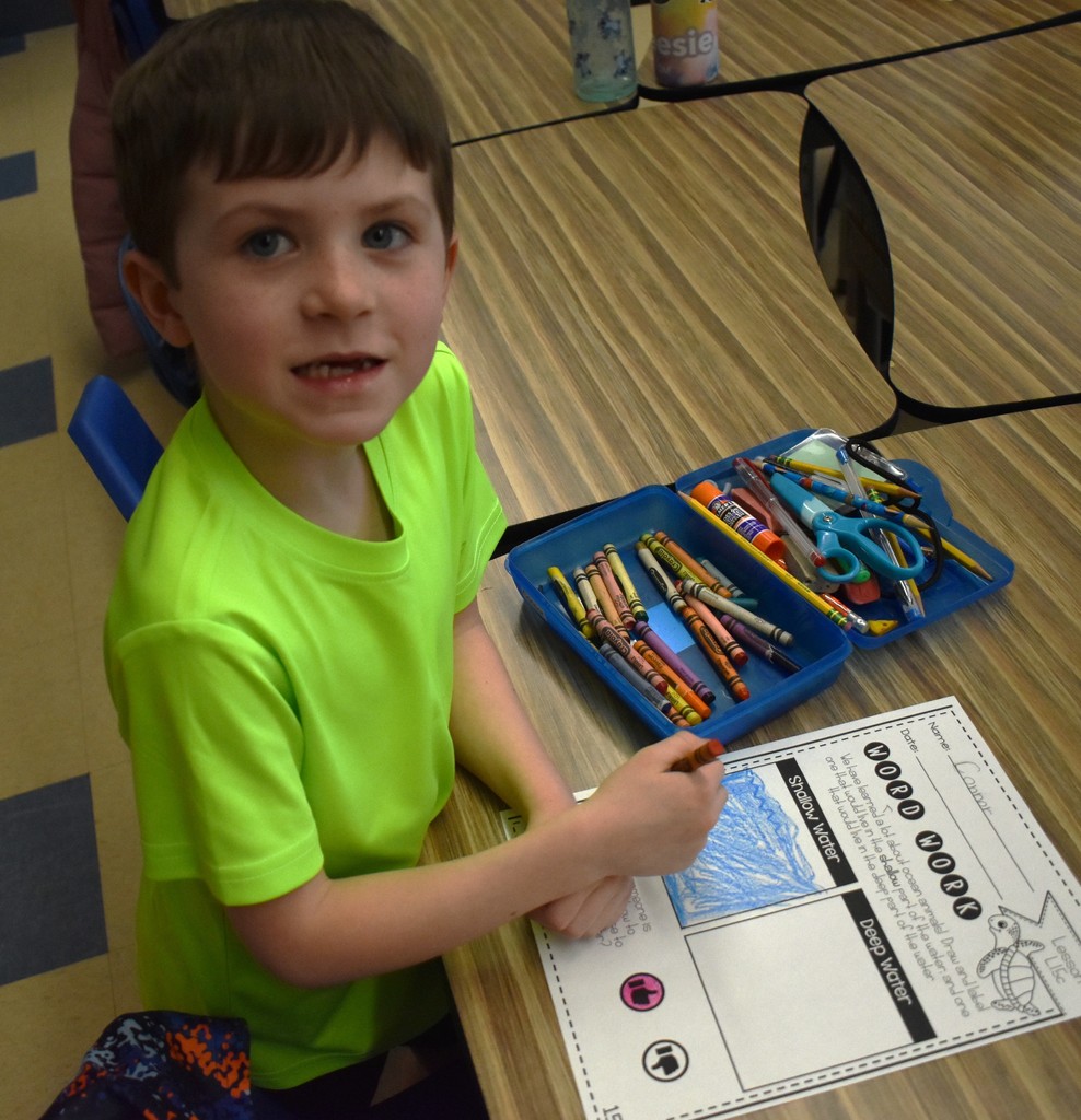 student in class with artwork