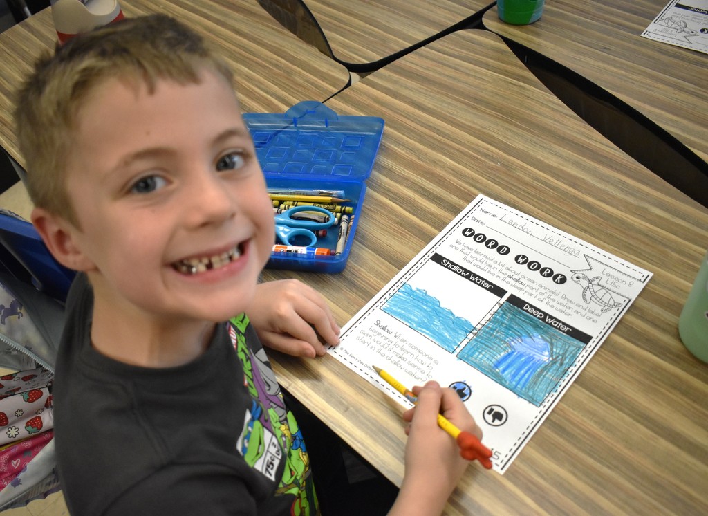 student in class with artwork