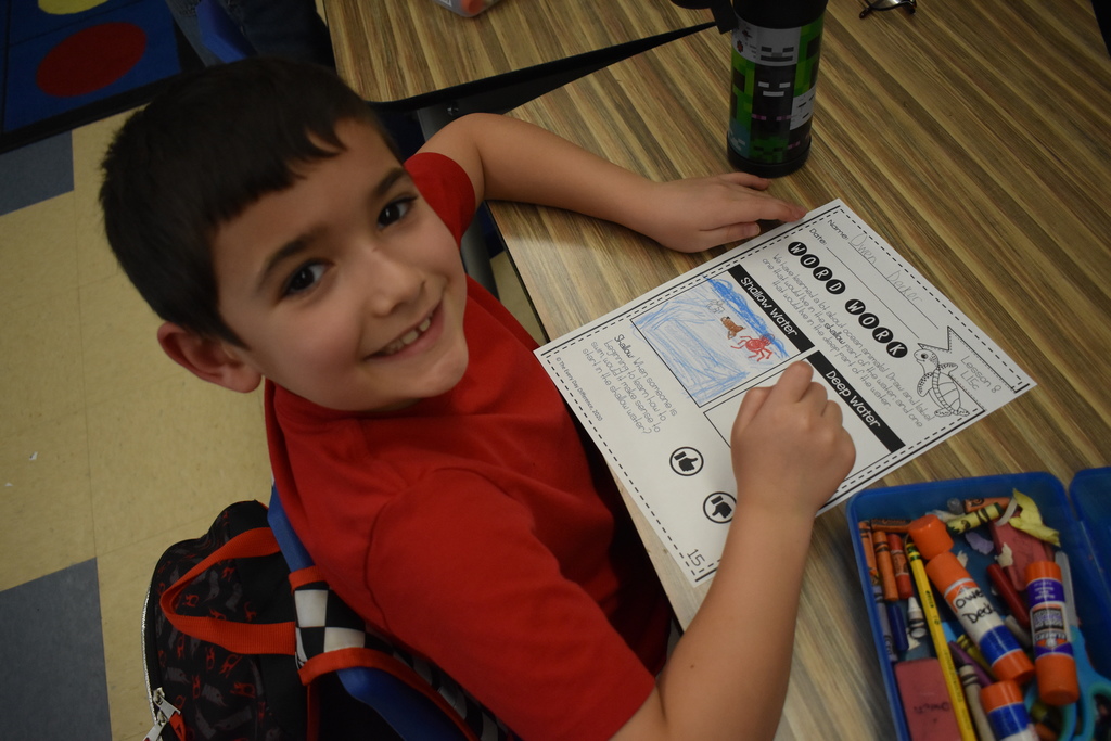 student in class with artwork