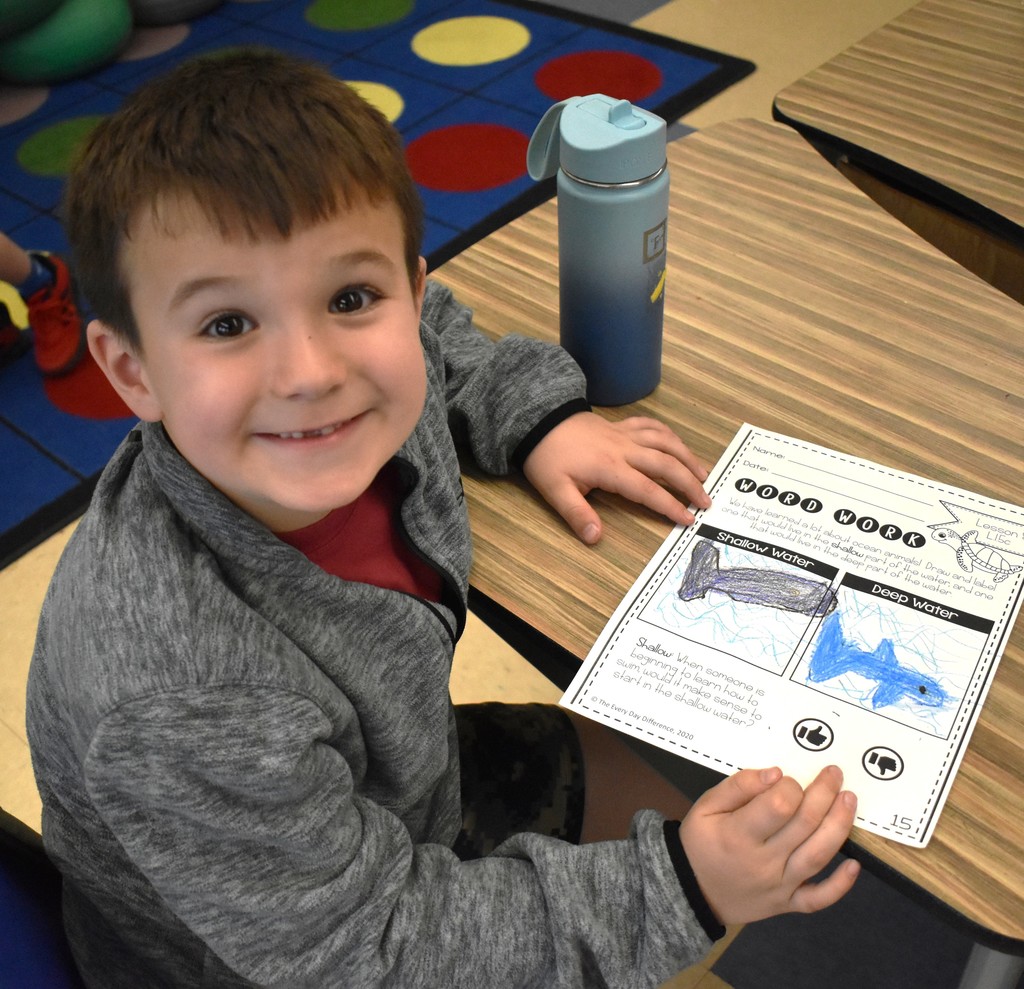 student in class with artwork