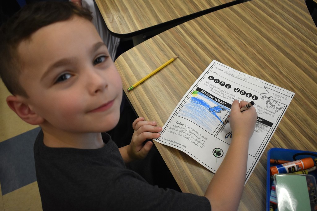 student in class with artwork