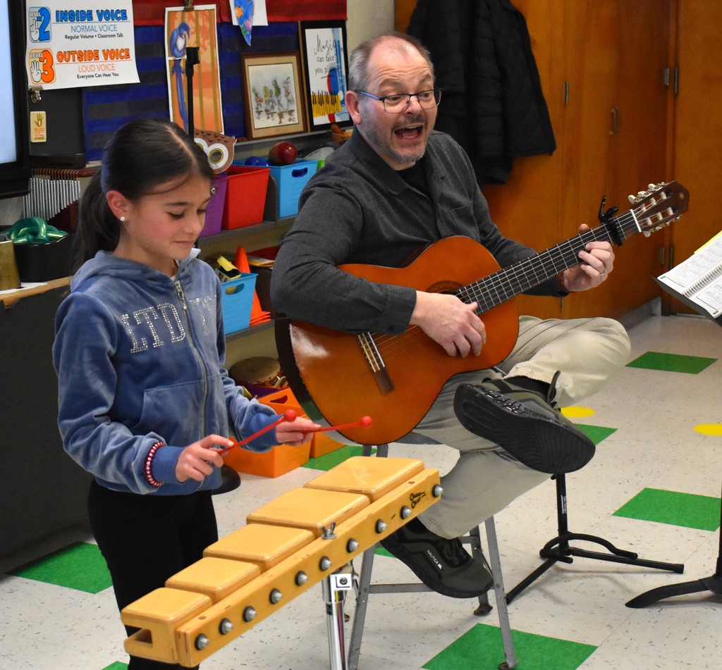 student and teacher in music class 