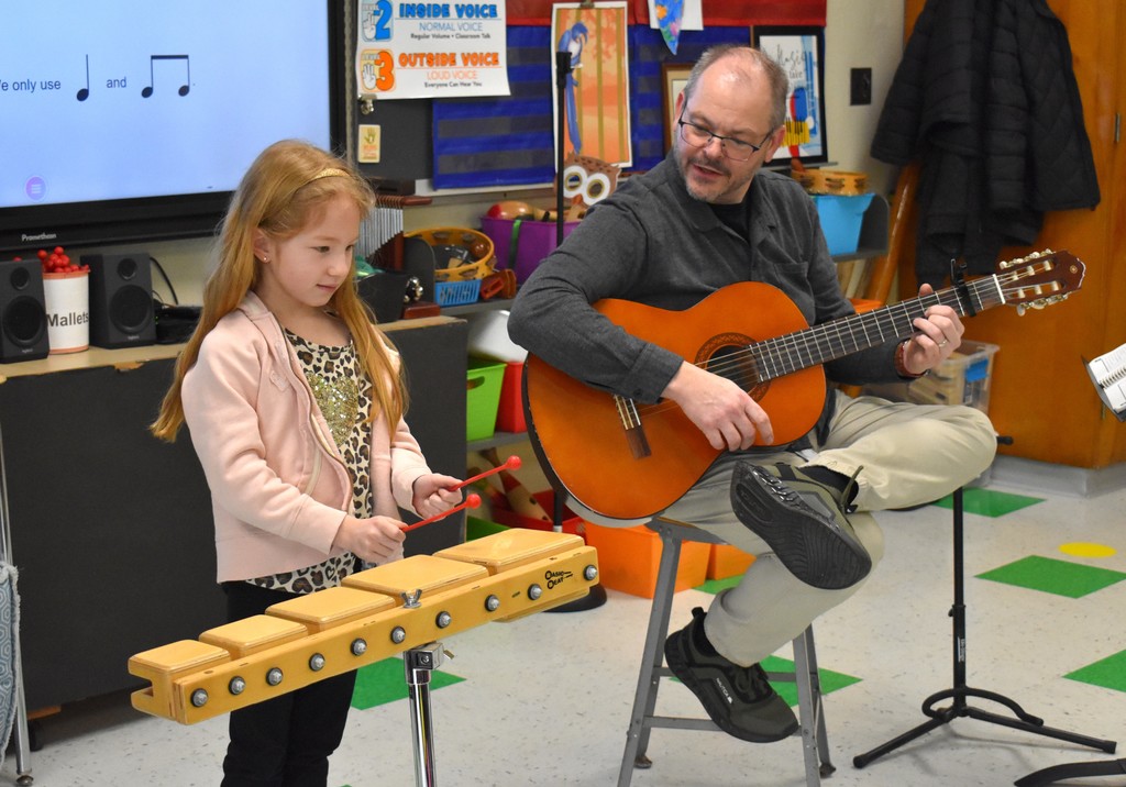 student and teacher in music class