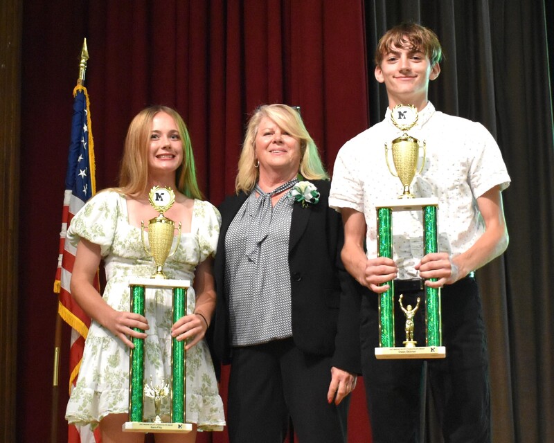 student with board member and trophies