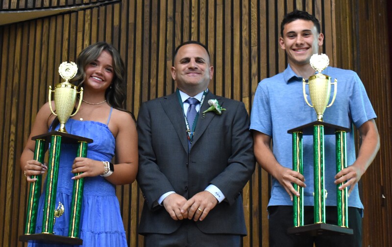 students with board member and trophies
