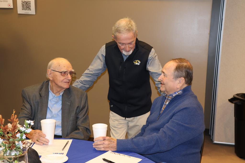 Three men chatting.