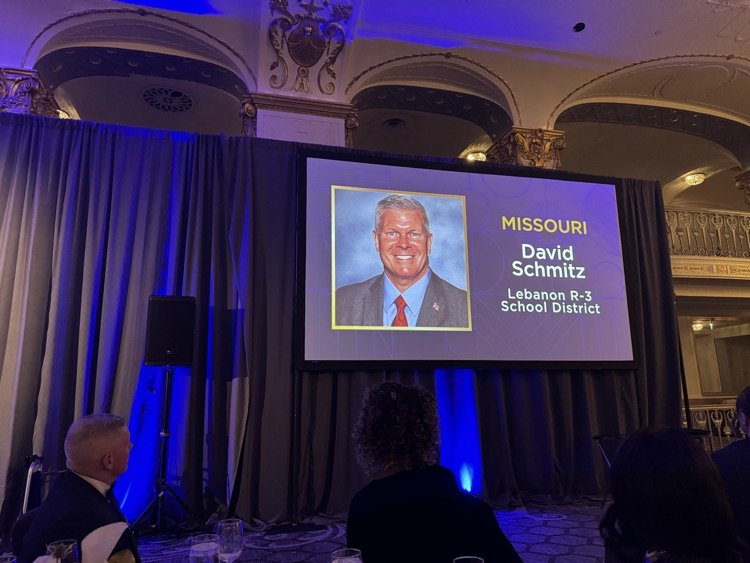 Dr. Schmitz picture and name on a projector screen in the ballroom