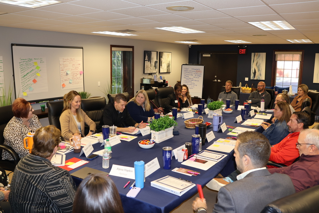 Participants sharing responses with eachother around a table. 