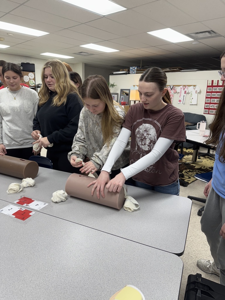Students participate in a hands-on tourniquet training exercise using practice cylinders.