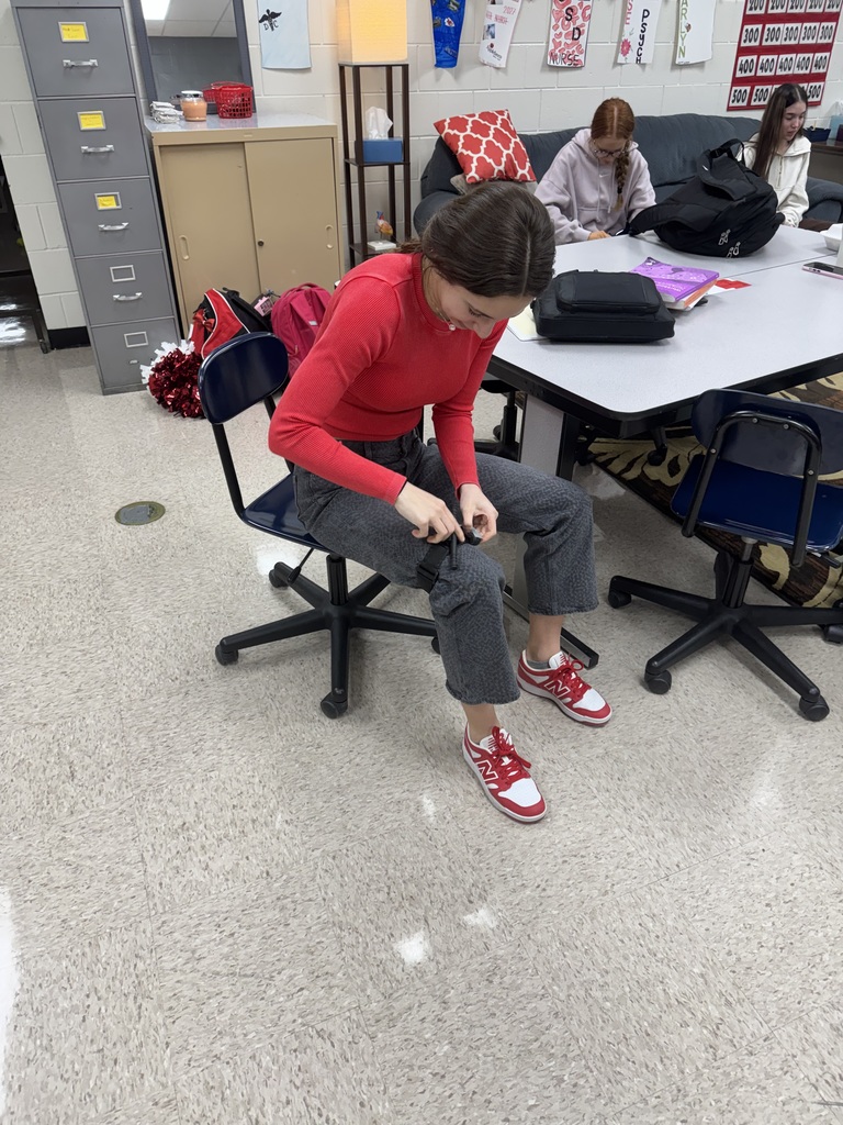 A student concentrates while practicing with a tourniquet during a classroom activity.