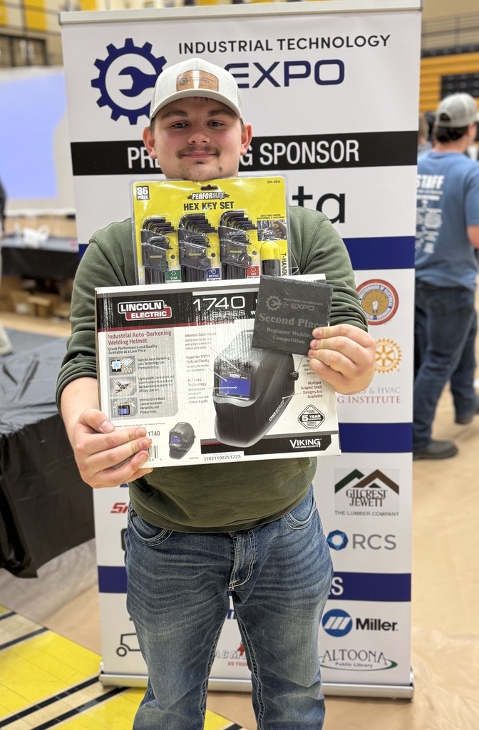 Student holding up a box and award.
