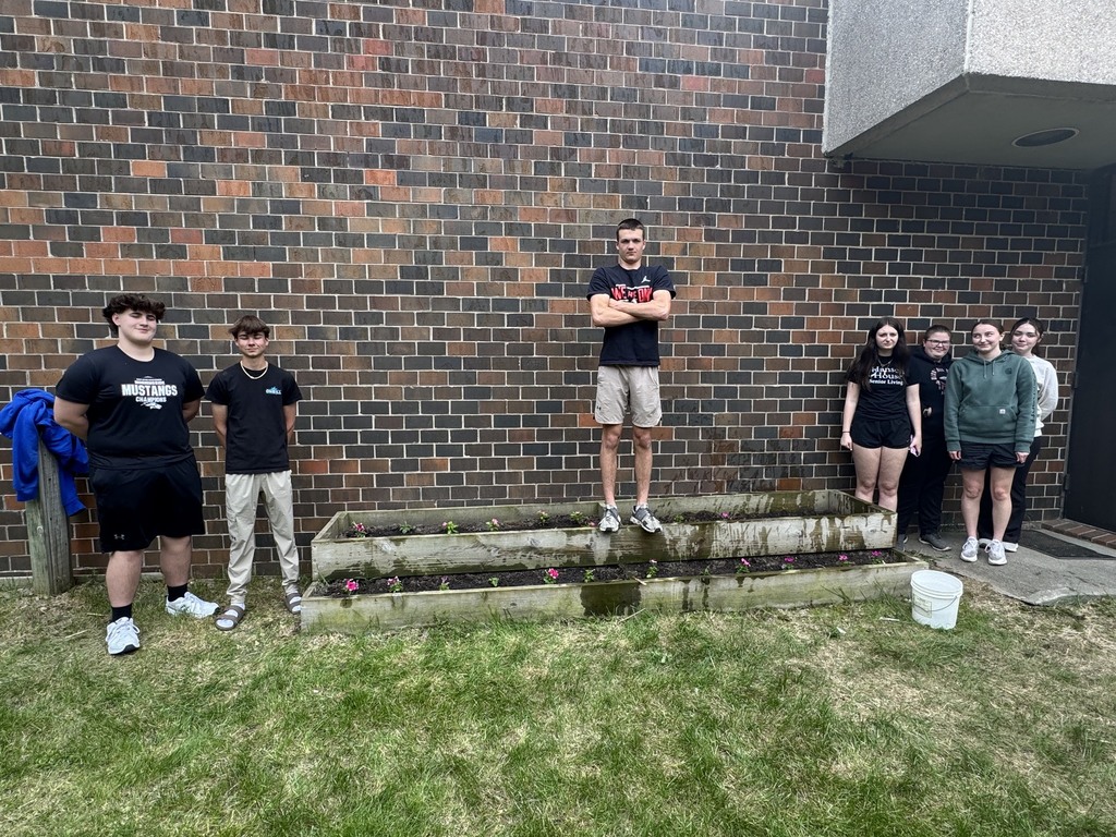 Students standing next to planter box.