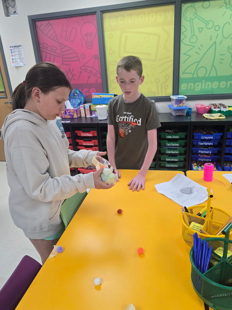 Two students working at a table.