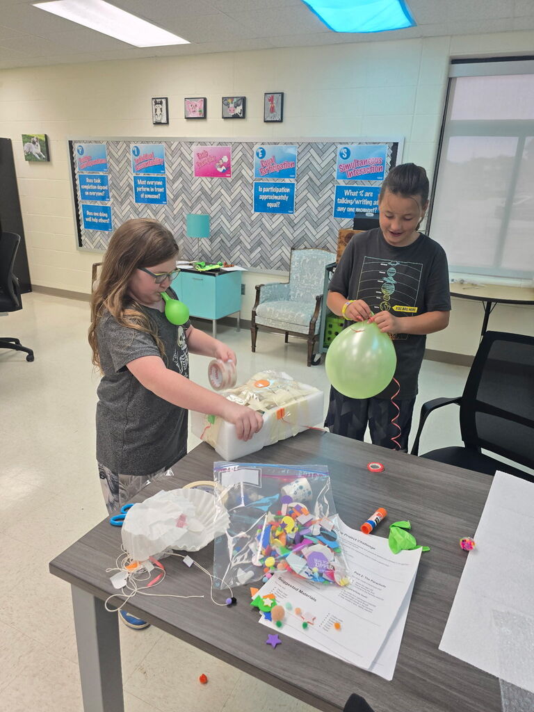 Two students working with balloons